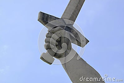 Statue hand holding the sword on the blue sky Stock Photo