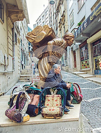 Statue of a hard working porter, Hamal, at Fatih district and living porter nowadays Editorial Stock Photo