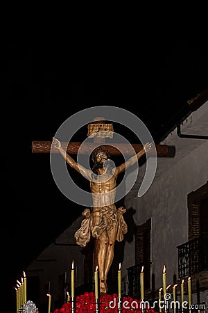 Statue of Jesus Christ hangs on the cross at night with lit candles at the religious processions Editorial Stock Photo
