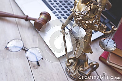 Statue of justice, judge gavel and laptop. Stock Photo