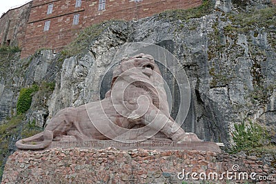 A statue of a lion made of pink sandstone in the fortress or citadel in Belfort, France. Editorial Stock Photo