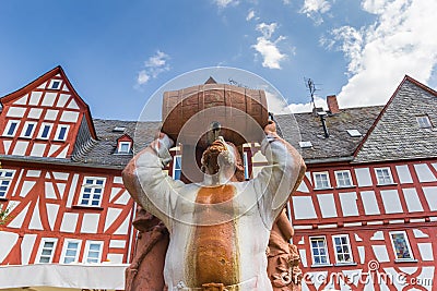 Statue of a man drinking from a barrel in Limburg Editorial Stock Photo