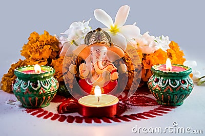 A statue of a mythological elephant god -Ganesha, surrounded by traditional divali lamps Stock Photo