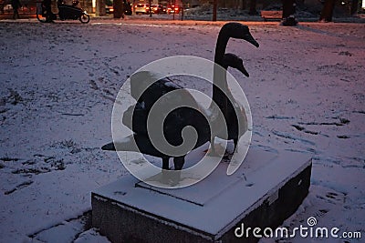 Statue of a pair of swans under the snow in December. Berlin, Germany Stock Photo