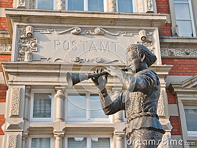 Statue of the Pied Piper from Hameln and the lettering "Postamt" in the background Editorial Stock Photo