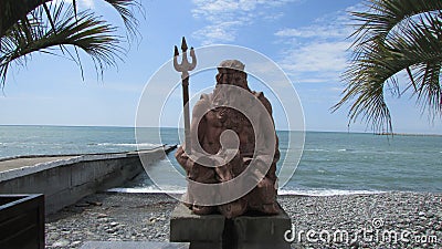 The statue of Poseidon on the seaside embankment in Sochi, southern Russia. Black sea, palm trees, pebble beach. Stock Photo