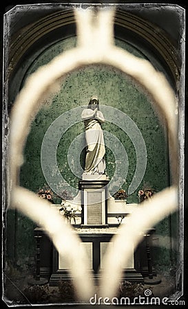 Statue of a praying virgin in a chapel in a cemetery Stock Photo