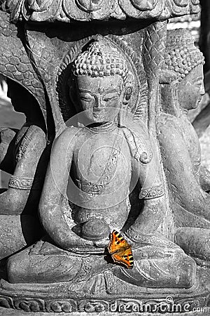 Statue of a sitting deity with butterfly Stock Photo