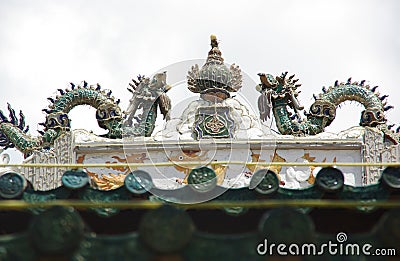 Statue of two dragons battling for ovum on the roof of a temple Stock Photo