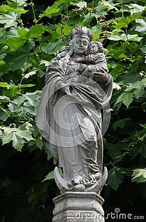 The statue of the Virgin Mary with the child Jesus in the courtyard of the church of St. Leodegar in Lucerne Stock Photo