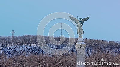 Statue winged Goddess of Liberty in front of Mont Royal with cross and radio mast , Montreal Editorial Stock Photo
