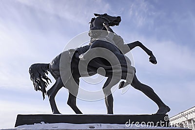 Statue of the young man, taking the horse by the bridle by Peter Clodt in Anichkov bridge. Sunny day view. Editorial Stock Photo