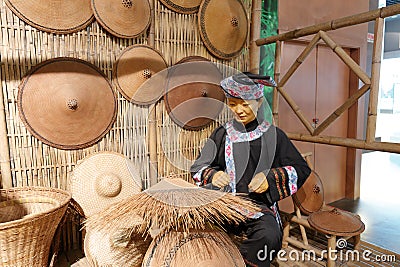 Statue of Zhuang woman weave straw rain clothes in Anthropology Museum Of Guangxi, adobe rgb Editorial Stock Photo