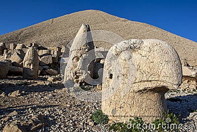 Statues of Apollo left, Zeus centre and and a Persian eagle god right on the weatern face at Mt Nemrut in Turkey. Stock Photo
