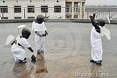 Poshtova Square, Kyiv, Ukraine 19 December 2020: statues of three little black children in angel costumes Editorial Stock Photo