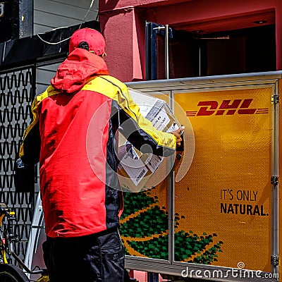 Local Worker Unloading And Delivering DHL Parcels Or Packages Editorial Stock Photo