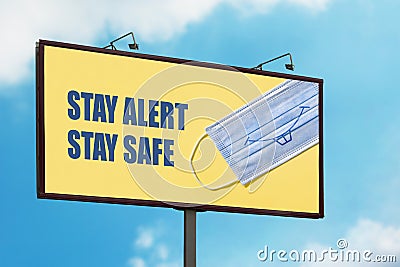 Stay Alert Stay Safe warning sign with smiling face mask on blue sky background. Large billboard with the message text Stock Photo