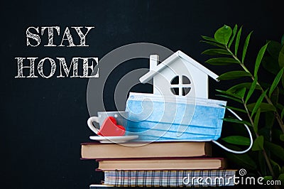 Stay home concept of selfisolation during the Covid-19 coronavirus pandemic. Cute home interior, house, books, flowers and the Stock Photo