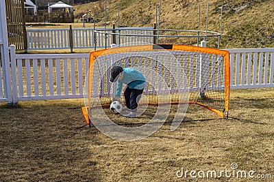Stay at home. COVID 19. Close up view of boy playing football on backyard. Outdoor games concept Stock Photo