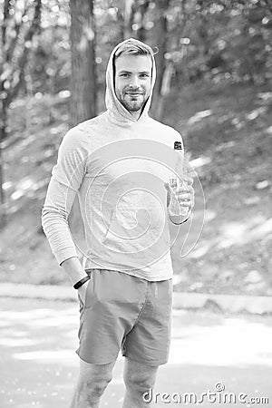 Stay hydrated. Athlete drink water after training in park. Man athlete sport clothes care about water balance. Healthy Stock Photo