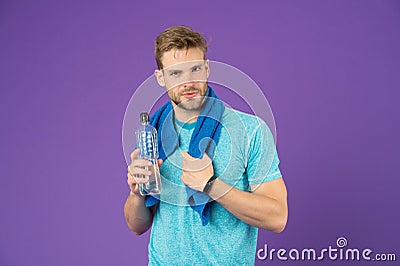 Stay hydrated. Drink some water. Man athlete with towel on shoulders holds water bottle. Man athlete sport clothes Stock Photo