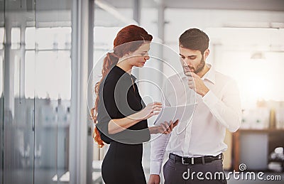 Staying ahead of the game with their strategy. two business colleagues discussing paperwork in the office. Stock Photo