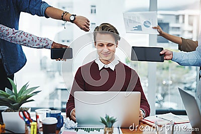 Staying cool under pressure. a young businessman using a laptop in a demanding office environment. Stock Photo