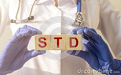 STD, Sexually transmitted infections, acronym text on wooden cubes in doctor hands in gloves Stock Photo