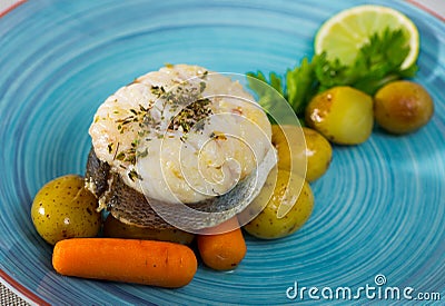 Cod by rustically frying and served with boiled potatoes, carrots and greens Stock Photo