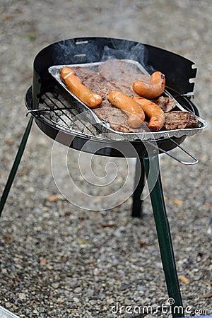 Steaks and sausages on grill Stock Photo
