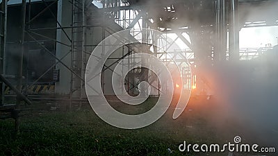 Steam leak in industial behind sunset background Stock Photo