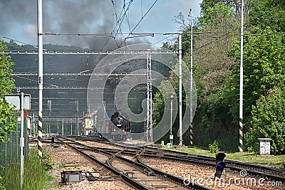 The steam locomotive departs from the station. Dense smoke rises from the chimney Editorial Stock Photo
