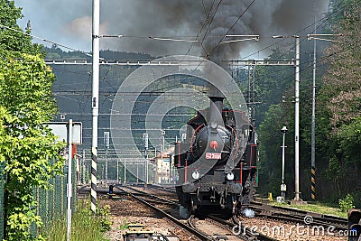 The steam locomotive departs from the station. Dense smoke rises from the chimney Editorial Stock Photo