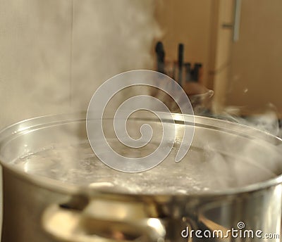 Steam over metal cooking pot Stock Photo