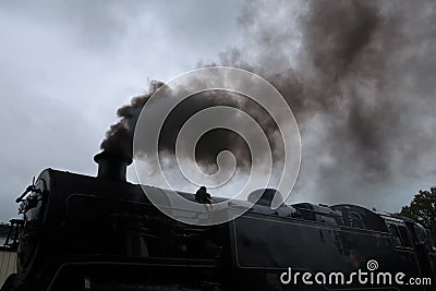 Steam train with smoke exiting its chimney. Editorial Stock Photo