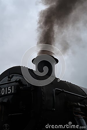 Steam train with smoke exiting its chimney. Editorial Stock Photo