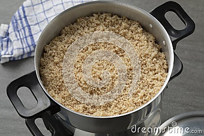 Steamed barley grits in a traditional aluminum food steamer close up Stock Photo
