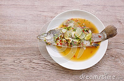 Steamed bass fish dressing lemon sweet and sour chili sauce on plate Stock Photo