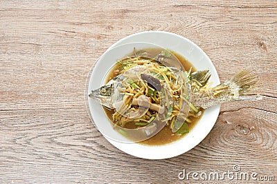 steamed bass fish dressing soybean gravy sauce topping slice ginger and mushroom on plate Stock Photo