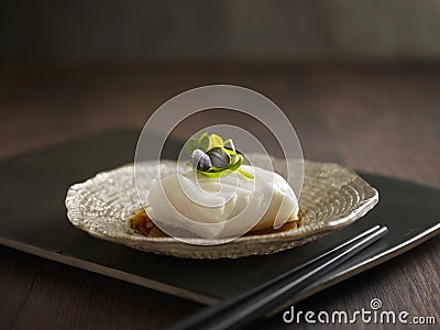 Steamed Cod Fish with Supreme Soya Sauce served in a dish isolated on wooden board side view dark background Stock Photo