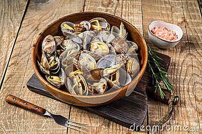 Steamed cooked shells Clams vongole in a wooden plate. wooden background. Top view Stock Photo