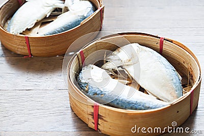 Steamed mackerels in basket on wooden table Stock Photo