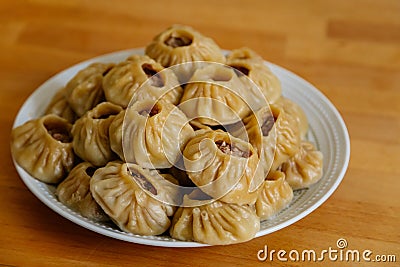 Steamed national Mongolian food dumpling Buuz filled with minced beef, white plate, wooden table, Close up east Siberian Buryats Stock Photo