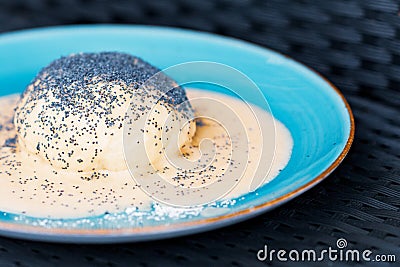 Steamed sweet dumpling bun topped with poppy seeds and vanilla sauce. Stock Photo