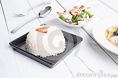 Steamed Thai jasmine rice in black plate with paco fern spicy sa Stock Photo