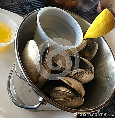 Steamers clams appetizer with water, melted butter, and slice lemon Stock Photo