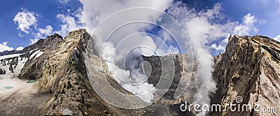 Steaming crater of active volcano covered by snow Stock Photo