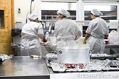 Steaming silver pot with three kitchen workers in restaurant Editorial Stock Photo