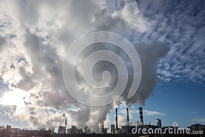 Steaming smoke stack and cooling tower with pollution Stock Photo