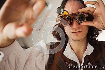 Steampunk style researcher mechanist of the monocle with a large number of lenses looking at something Stock Photo